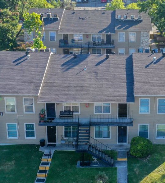 an aerial view of a residential complex with a green lawn at The Calypso Apartments