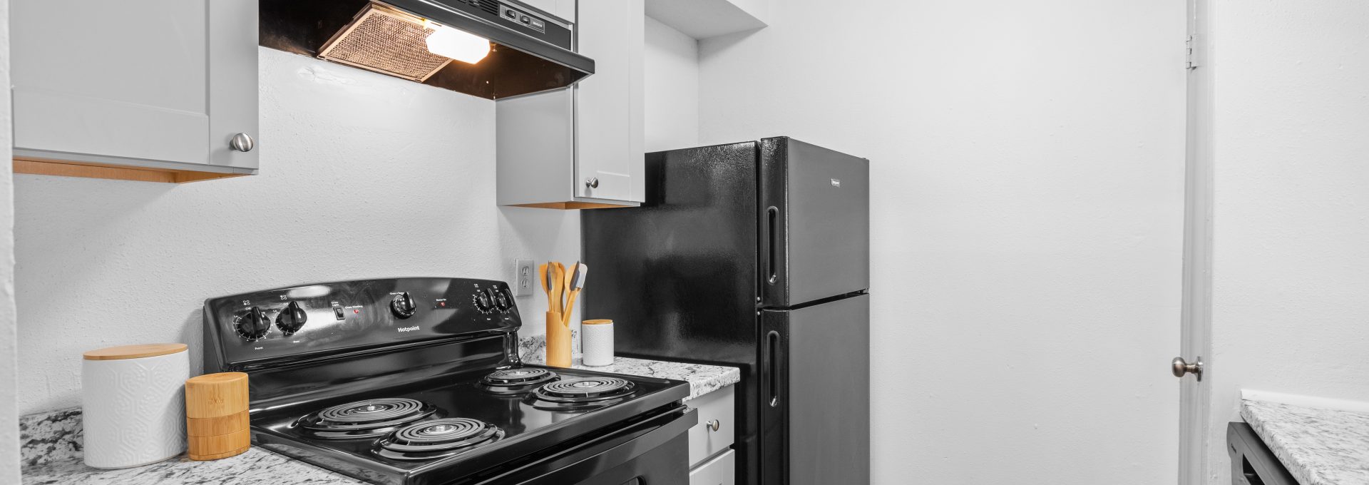 a black and white kitchen with a stove and oven at The Calypso Apartments