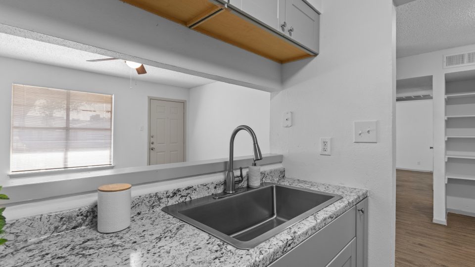 a kitchen with granite counter tops and stainless steel appliances at The Calypso Apartments