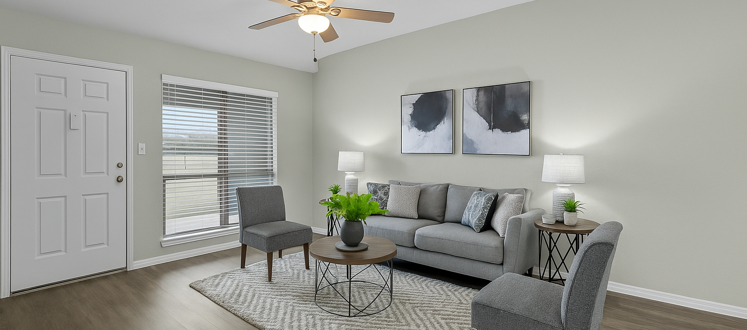 a living room with a ceiling fan and hardwood floors at The Calypso Apartments